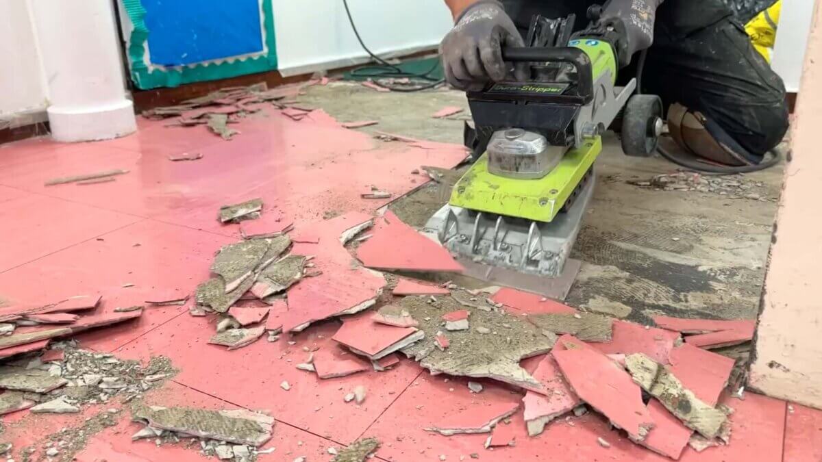 Ripping up the old hallway flooring tiles at Wyndcliffe Primary School