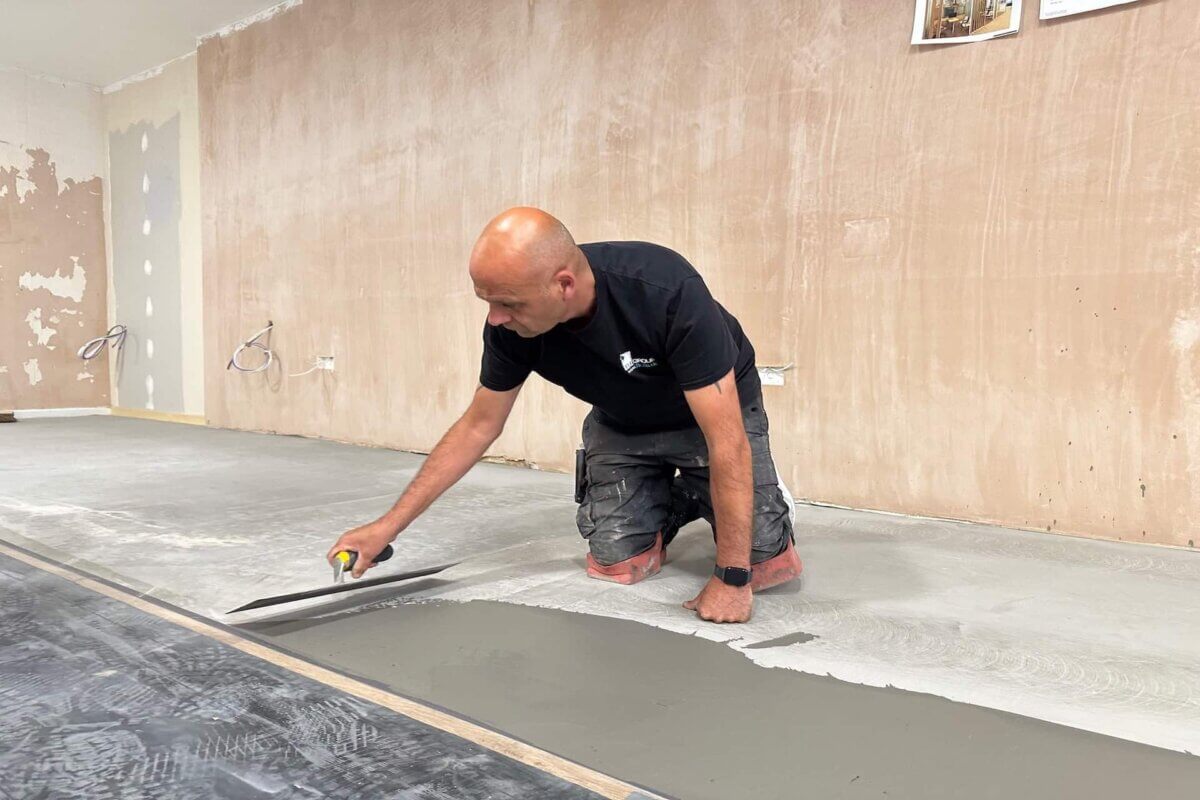Senior fitter applying latex to floor opticians