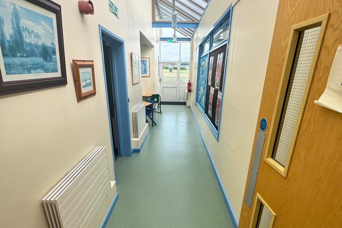 An interior shot of a school corridor showcasing green vinyl flooring