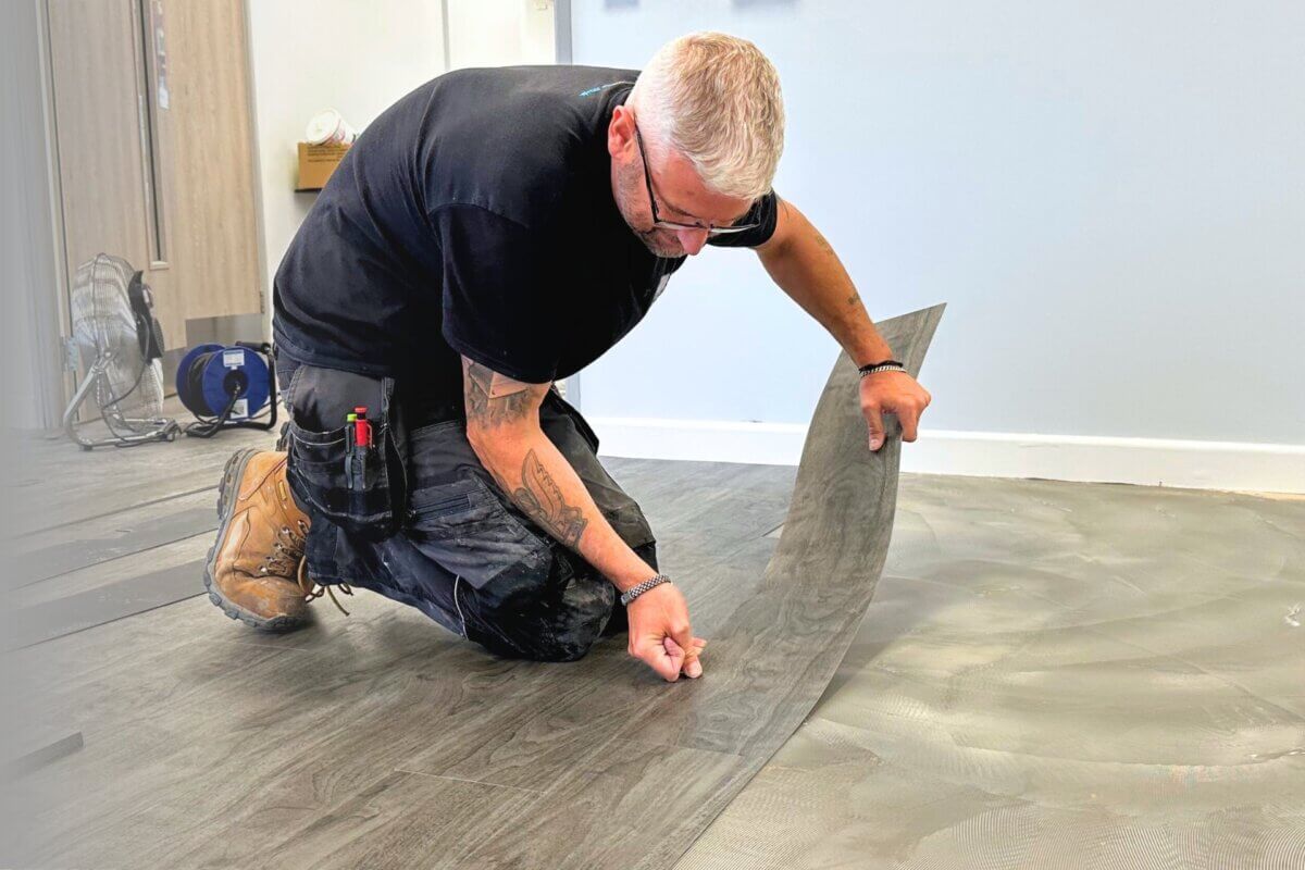 Shot of flooring installer installing vinyl plank