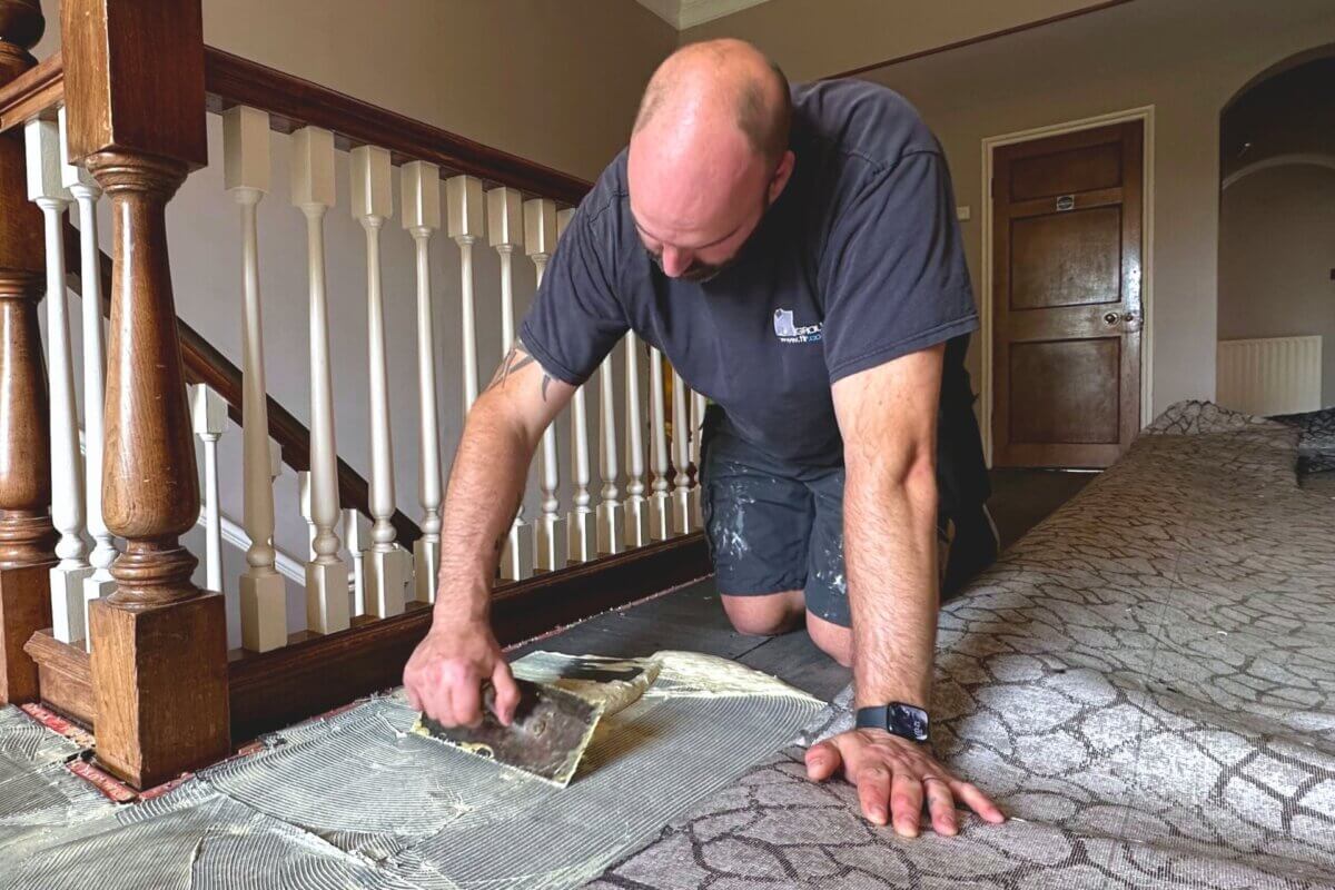 Interior shot of floor fitter installing carpet at a hotel