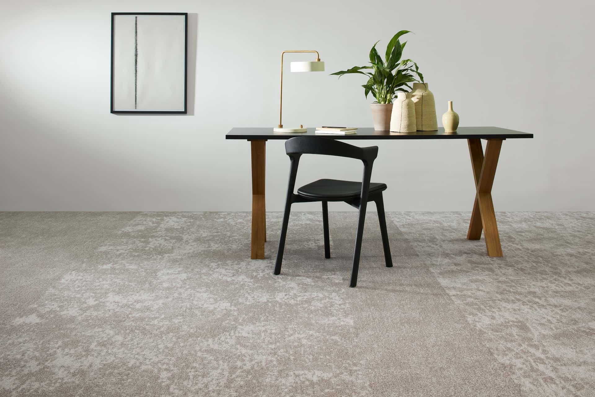 Minimalist workspace interior featuring soft neutral Milliken carpet tiles, contemporary desk and chair, with biophilic styling and clean, modern design.